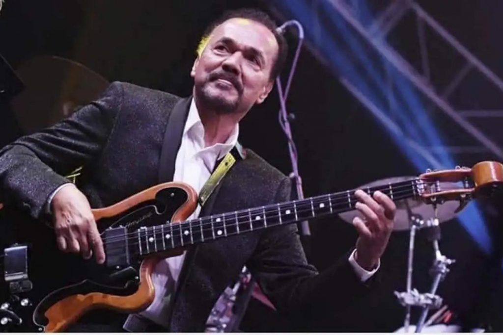 El salsero Bobby Valentín tocando su bajo con pasión durante una presentación en vivo sobre el escenario, como parte de su trayectoria de 60 años.