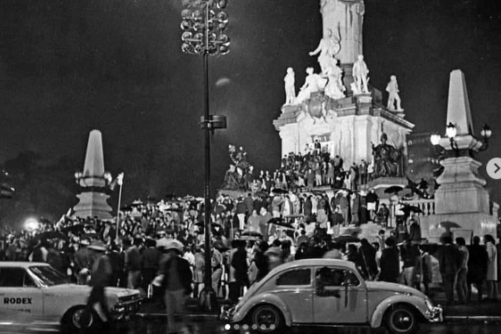 Aficionados celebrando en el Ángel de la Independencia durante el Mundial de México 86. La nota recuerda cómo se vivían los festejos en las calles de la ciudad con música de cumbia y salsa.