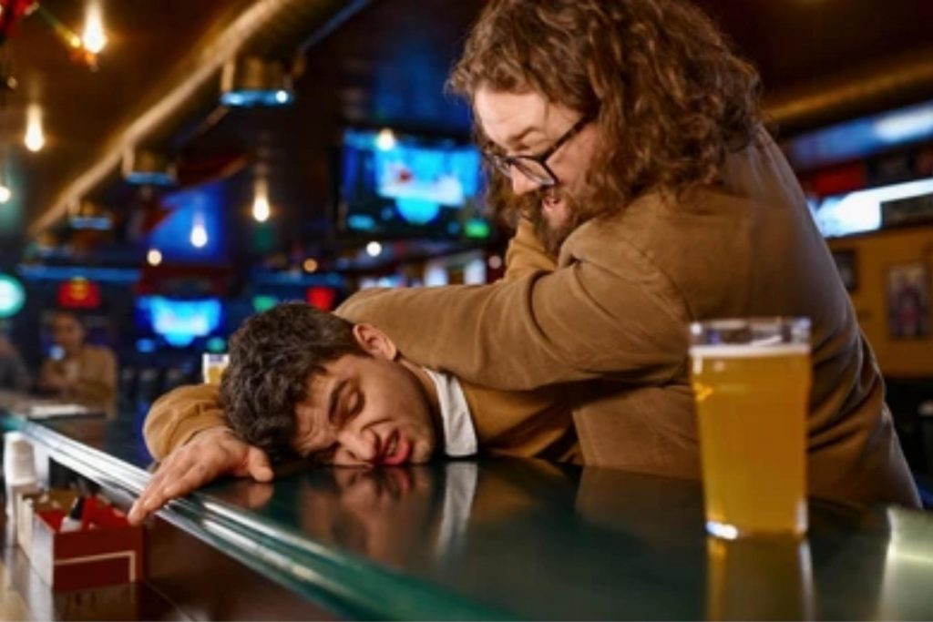 Un hombre deteniendo a otro en un bar, representando la analogía de los defensas, que son como los tíos rudos que actúan como seguridad en la fiesta familiar.