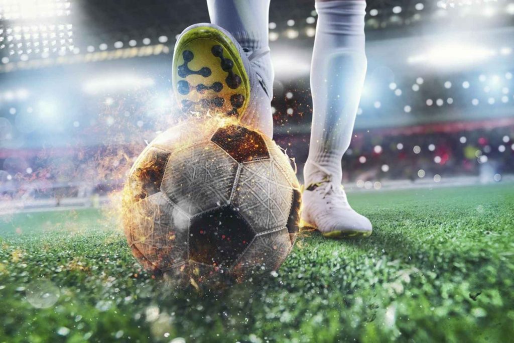 Un balón de fútbol en llamas a punto de ser pateado, representando la pasión y los tiros potentes que los comentaristas describen con frases como "perforó la red".